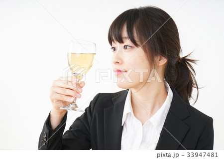 スーツ姿でお酒を飲む若い女性 スーツ姿でお酒を飲む若い女性 33947481