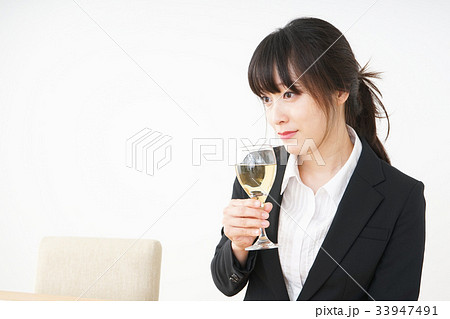 スーツ姿でお酒を飲む若い女性 スーツ姿でお酒を飲む若い女性 33947491