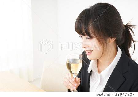 スーツ姿でお酒を飲む若い女性 スーツ姿でお酒を飲む若い女性 33947507