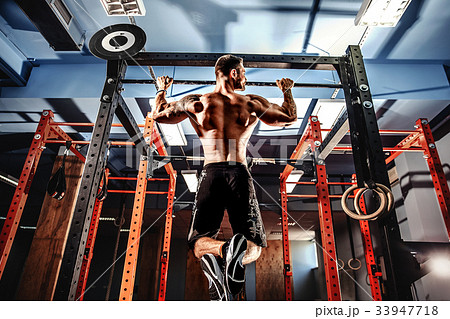 Shirtless man pulling up on horizontal bar. Shirtless man pulling up on horizontal bar. 33947718