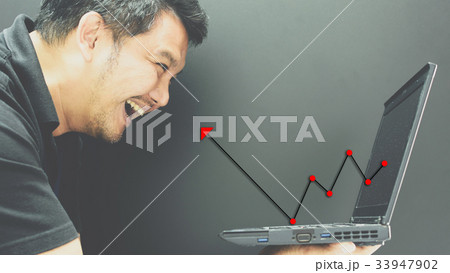 Asian man and computer stock market graph growth 33947902