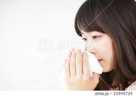 鼻をかむ若い女性の写真素材