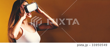 Young woman using virtual reality headset 33950549