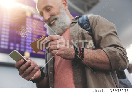 Pensioner writing in mobile and keeping card 33953558