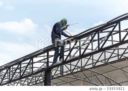 Worker welding the steel part 33953921