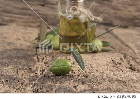 Unripe olives and olive oil on wooden table Unripe olives and olive oil on wooden table 33954699