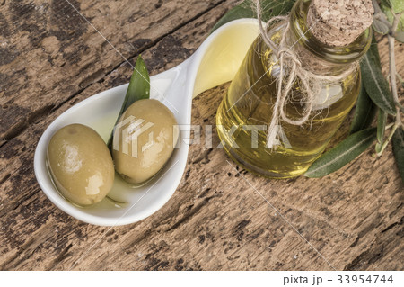 Olives and olive oil on wooden table Olives and olive oil on wooden table 33954744