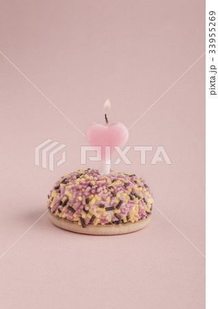birthday cake with heart shaped candle on pink 33955269
