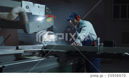 The joiner works on a sawing machine The joiner works on a sawing machine 33956070