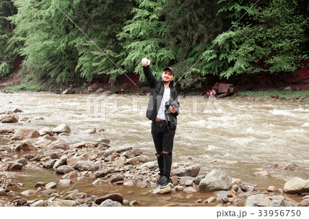guy doing selfie on the background of rough river 33956750
