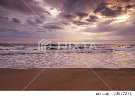 Majestic ocean sunset with a breaking wave 33957271