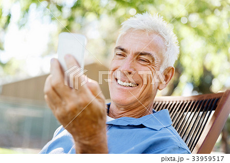 LoMature man outdoors using mobile phone 33959517