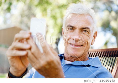 LoMature man outdoors using mobile phone 33959518