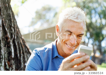 LoMature man outdoors using mobile phone LoMature man outdoors using mobile phone 33960534