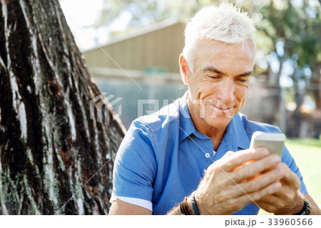LoMature man outdoors using mobile phone LoMature man outdoors using mobile phone 33960566