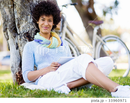 Young woman using tablet in the park. 33960971