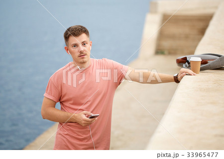 Guy listens to music and drinks coffee 33965477