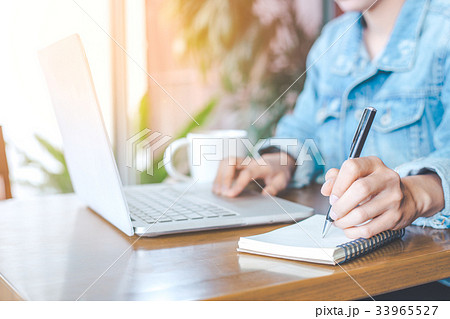 A woman's hand working on a notebook computer 33965527