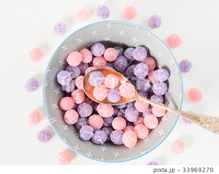 Purple and pink candies in bowl 33969270
