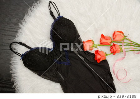 Black lace body on white fur and bouquet of roses 33973189