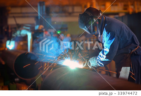 Welder performs welding large diameter pipe 33974472