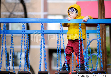 Little boy having fun on outdoor playground 33998318