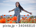 Woman in patterned sundress on flower field 34046810