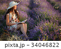 Romantic woman sits with book on lavender field 34046822