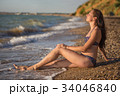 Dreamy woman sits in the sea surf 34046840