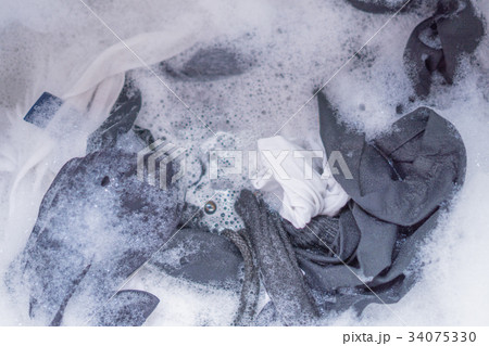 Washing clothes in the washing machine. 34075330