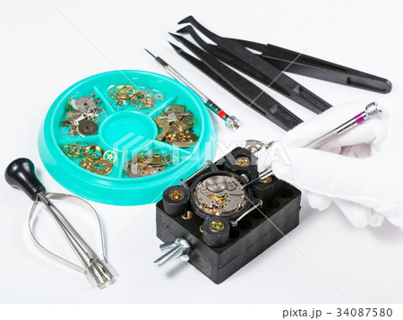 repairing old mechanical watch on white table 34087580