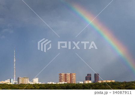 sunbeams and rainbow in rainy sky over city sunbeams and rainbow in rainy sky over city 34087911