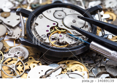 tools on open watch on heap of clock spare parts tools on open watch on heap of clock spare parts 34089139