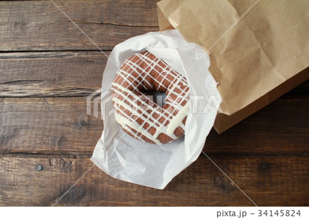 紙袋から出した持ち帰りのチョコレートドーナツ 紙袋から出した持ち帰りのチョコレートドーナツ 34145824