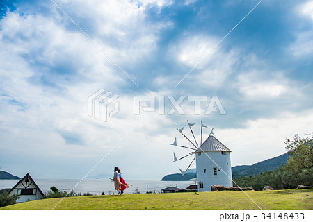 小豆島　道の駅　初夏のオリーブ公園　ギリシャ風車の前で魔法のほうきに乗る女性 34148433
