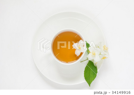 Jasmine flowers and cup of green tea on white. 34149916