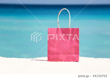 Shopping bag on sand against caribbean sea water Shopping bag on sand against caribbean sea water 34150703