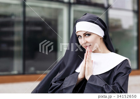 Young nun with bright makeup praying outdoors. Young nun with bright makeup praying outdoors. 34152650