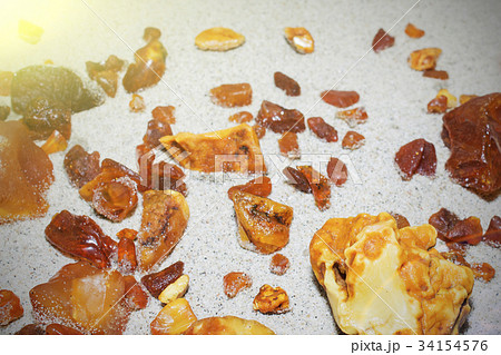 Amber. the pieces of amber in the sand on the Amber. the pieces of amber in the sand on the 34154576