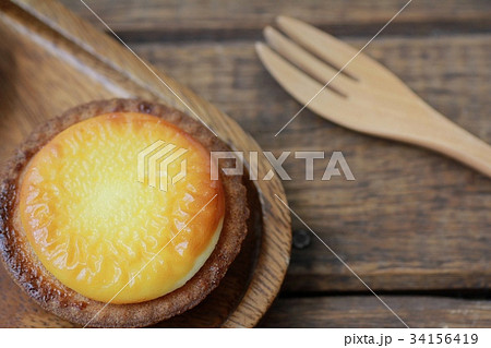 しっとりサクサクのベイクドチーズタルトと木のフォーク 34156419