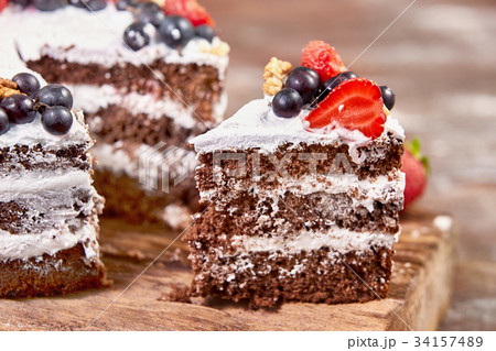 a cut of cake with whipped cream and strawberry 34157489