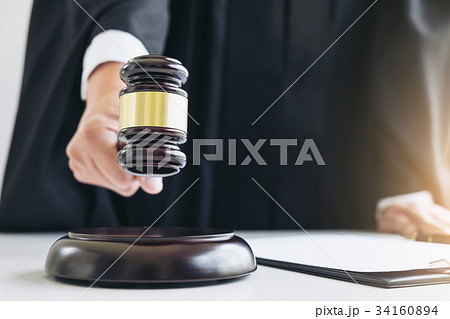 Close up of Male lawyer or judge hand's striking the gavel on so Close up of Male lawyer or judge hand's striking the gavel on so 34160894