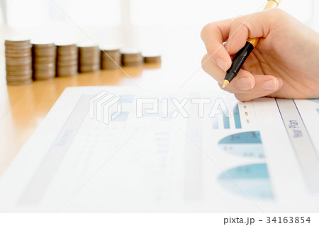 Businesswoman Analyzing Financial Graph With Coins 34163854