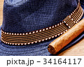 blue hat and cigar on wooden floor, smoke concept 34164117