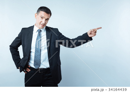 Pleasant nice businessman pointing to the right 34164439