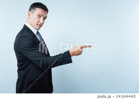 Handsome nice entrepreneur pointing in front of 34164440