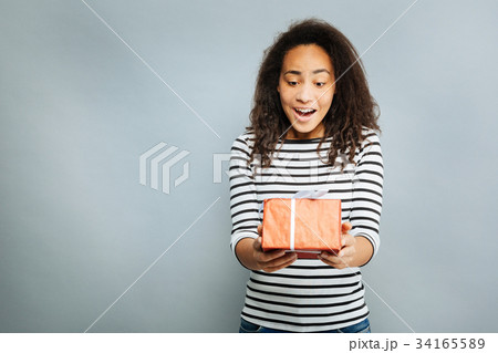 Surprised brunette looking at gift box Surprised brunette looking at gift box 34165589