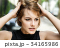 Girl brushing her hair through with fingers. 34165986