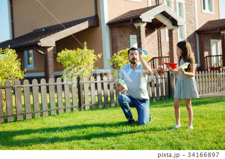 Caring father showing daughter how to launch paper Caring father showing daughter how to launch paper 34166897