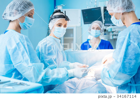 Serious doctor looking at her assistant 34167114